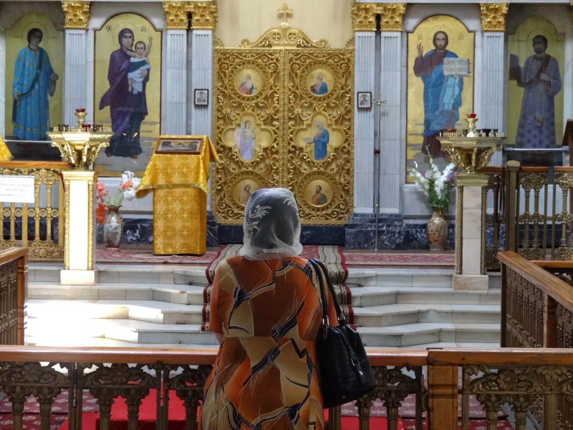 Femeie în rugăciune într-o biserică ortodoxă